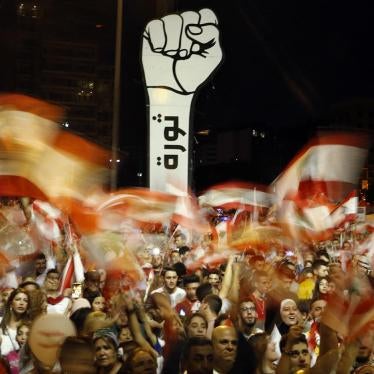 Anti-government protesters wave Lebanese flags during ongoing anti-government protests, in Beirut, Lebanon, November 10, 2019. The Arabic on the fist reads "Revolution."