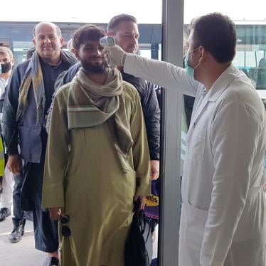 A medical officer scans a passenger for signs of fever at a bus station as a precaution against the coronavirus in Kabul, Afghanistan, March 27, 2020. © 2020 Sayed Khodaiberdi Sadat/Anadolu Agency via Getty Images