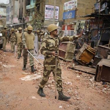 An Indian paramilitary soldier asks residents to stay indoors as they patrol a street vandalized in February 25th's violence in New Delhi, India, February 27, 2020.