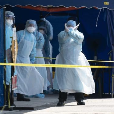 A health worker in a protective suit gestures in a tent erected to test for the new coronavirus at a clinic in Kuala Lumpur, Malaysia, March 24, 2020.  