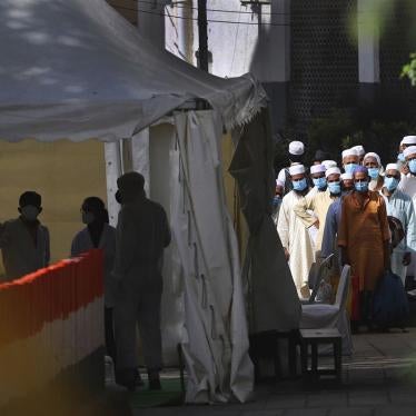 Men wait for a bus that will take them to a quarantine facility in the Nizamuddin area of New Delhi, India, March 31, 2020.