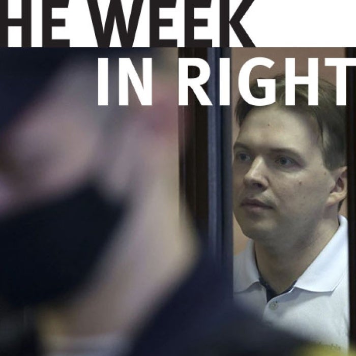 Maksim Znak appears behind bars. 