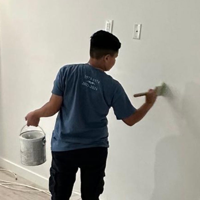 Photo of a woman painting a wall